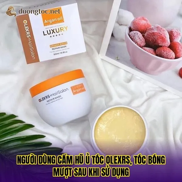 Người dùng cầm hũ ủ tóc Olexrs, tóc bóng mượt sau khi sử dụng